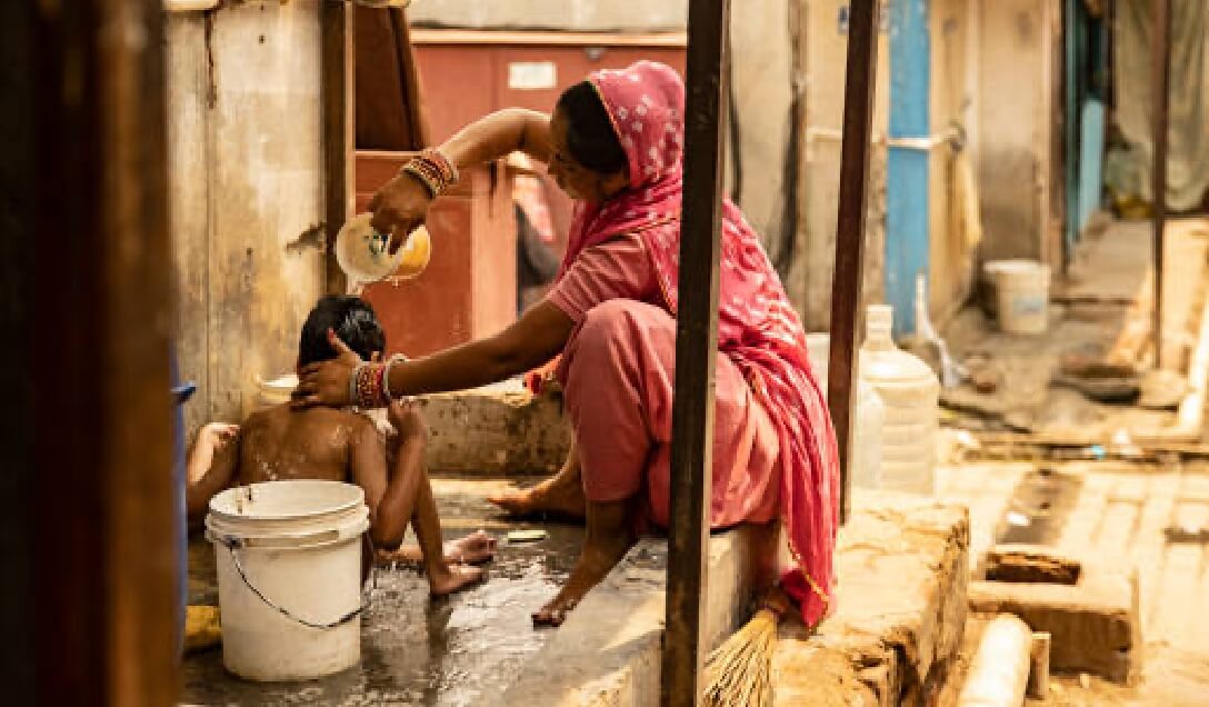 街中で子供の体を洗うインドの女性